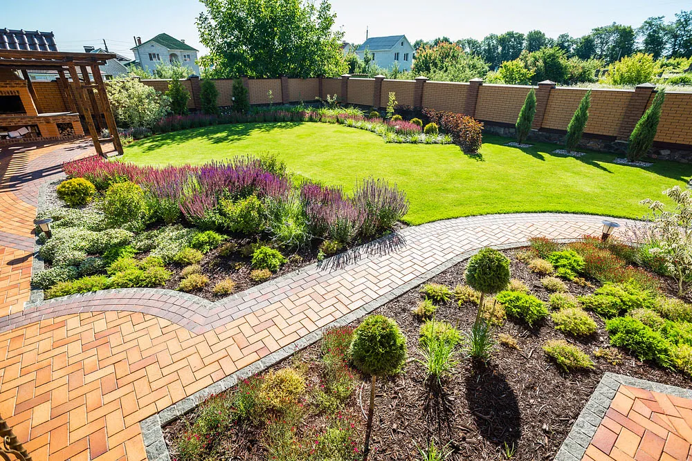 Landscaped garden with a curved block-paved path and lawn