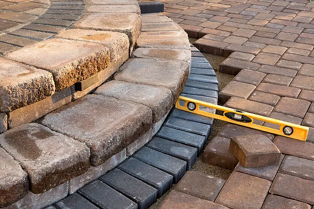 Close-up of curved patio block edging and a spirit level