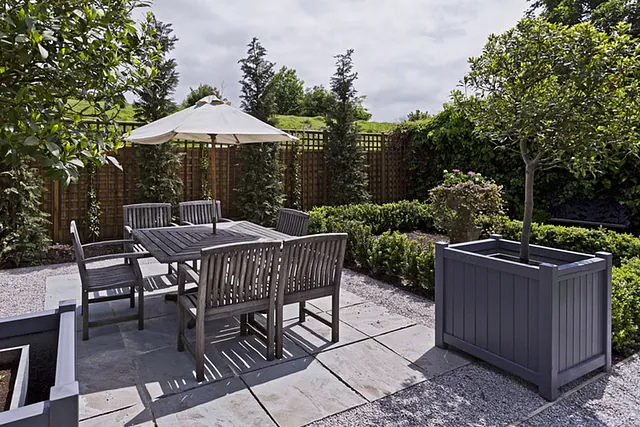 Patio dining area with paving and planters
